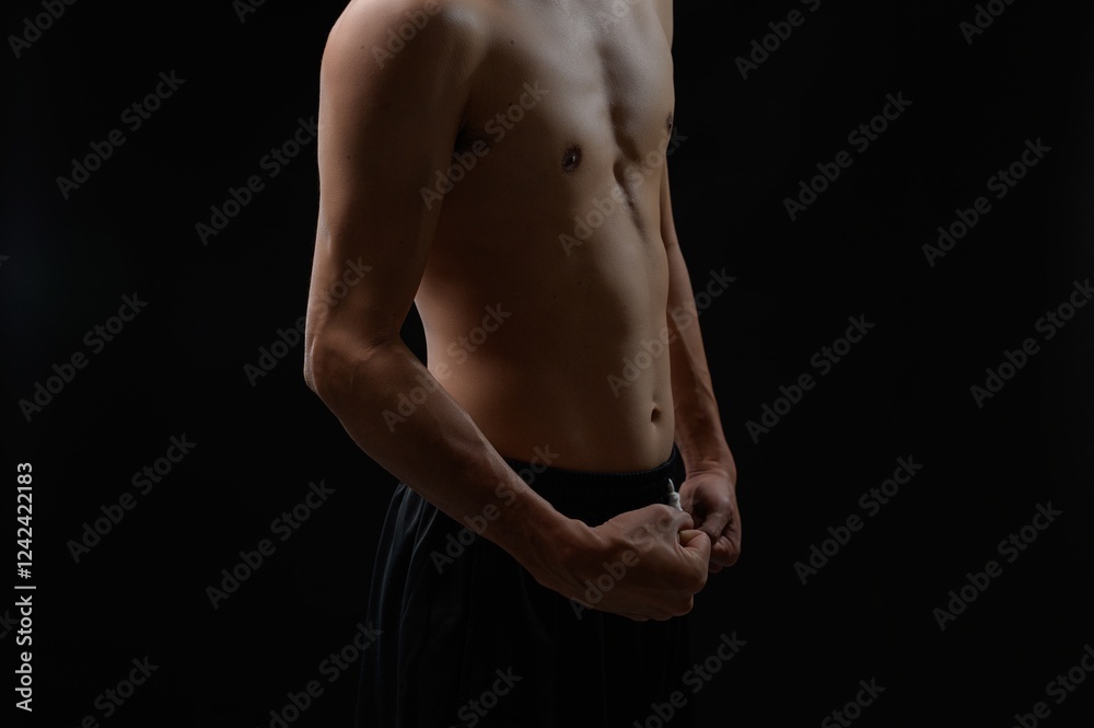 Muscular Male Torso Highlighting Strength and Fitness in Dark Background Muscular Male Torso Highlighting Strength and Fitness in Dark Background