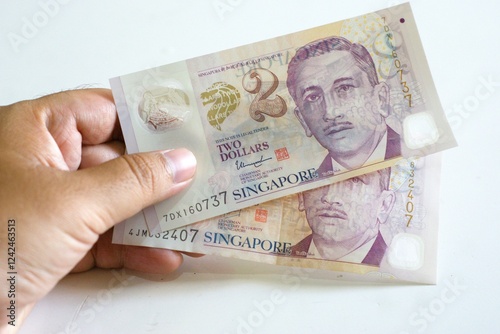 Photography Hand holding Singapore dollar currency banknotes, concept of cash paying and bus