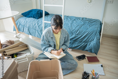 Фотография Student asian woman organize room unpack in dorm room college student moving to new  university dormitory or preparing to move out
