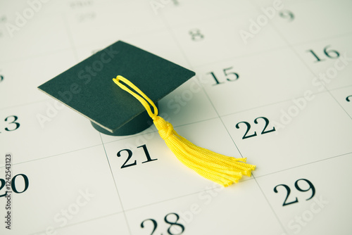 Graduation cap or mortarboard on white blank calendar background. University graduation ceremonies on commencement day schedule. Education, learning successful for future concept.
