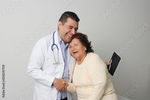 Elderly 80-year-old Latin woman visits the dark-skinned geriatric specialist medical doctor to check her health, they greet each other, laugh and hug