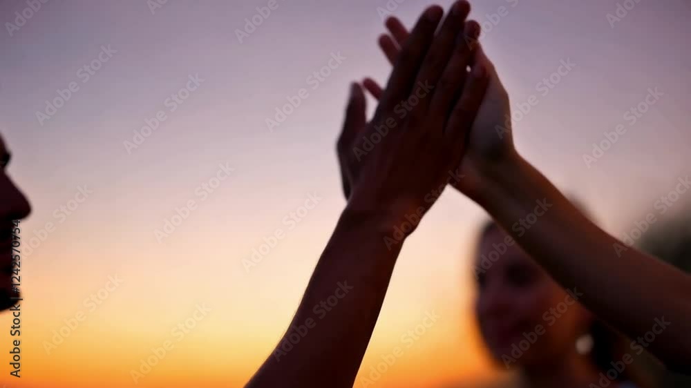 Two hands giving high five with the blurry sunset background Two hands giving high five with the blurry sunset background