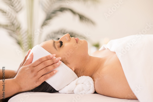 Woman relaxing laying down and having hands massage her temples photo