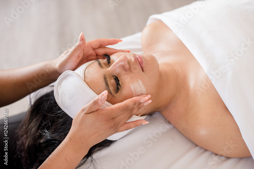 Product being applied to womans face during facial photo