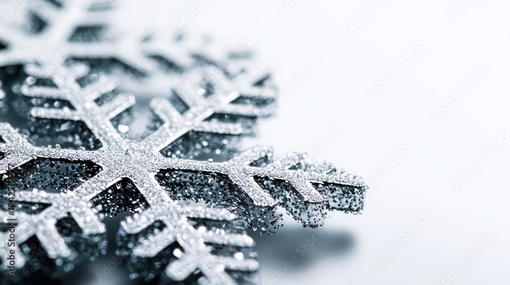 Fototapeta premium A close-up of a glittering silver snowflake on a light background.