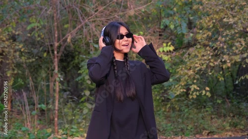 Modern and carefree, a young woman uses her wireless earphones to connect with the joyful rhythm of life.