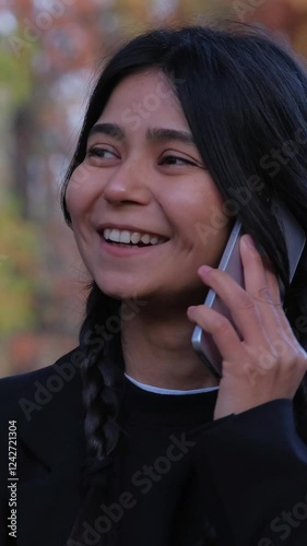 Fashionable young female shares a heartfelt conversation on her phone