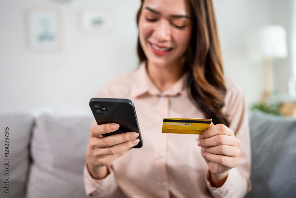 Asian woman using mobile phone shopping online in living room at home. Asian woman using mobile phone shopping online in living room at home.