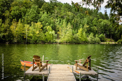 Peaceful Lake Dock with Adirondack Chairs and Canoe in Quebec