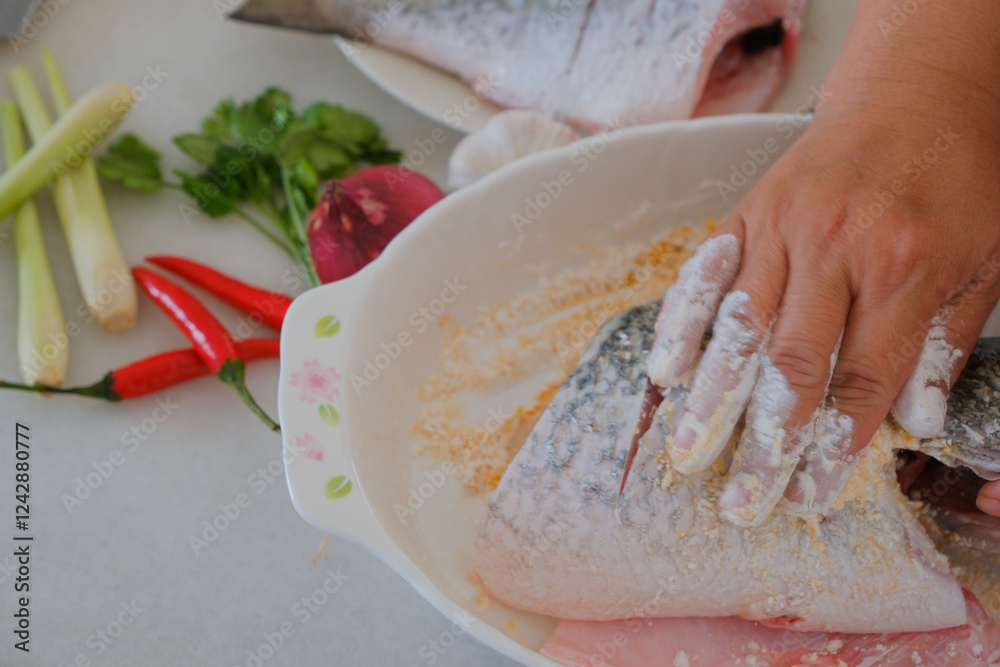 Hands of woman chef preparing fish food
