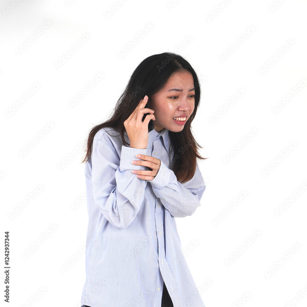 Upset woman wearing blue shirt hearing bad news from cell phone. Online call and chat themed photo isolated on square white background. Upset woman wearing blue shirt hearing bad news from cell phone. Online call and chat themed photo isolated on square white background.