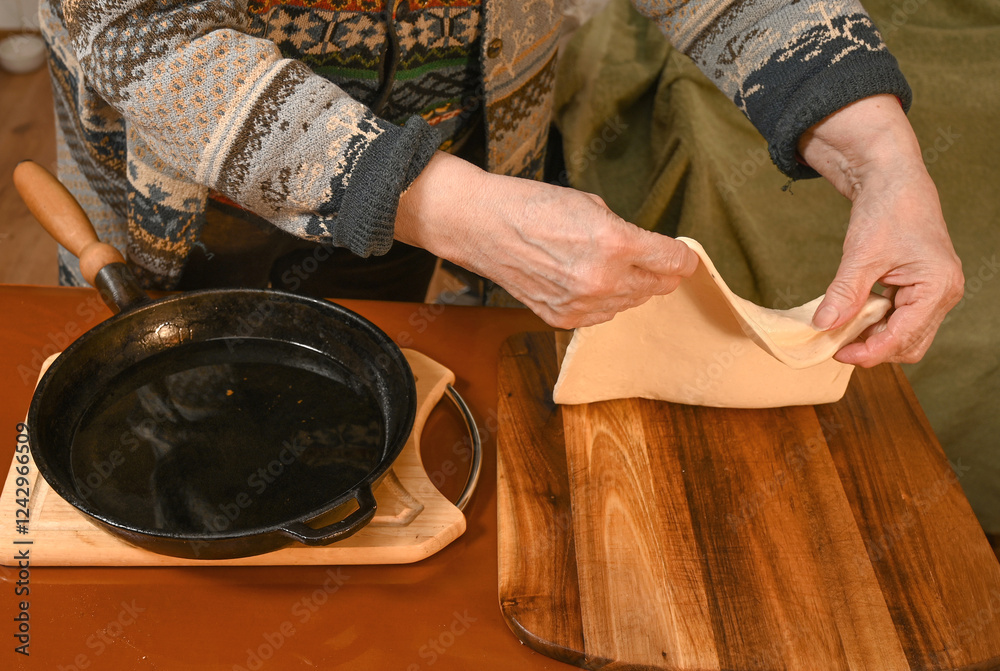 Preparing dough for traditional cooking in a cozy kitchen setting with a cast iron skillet