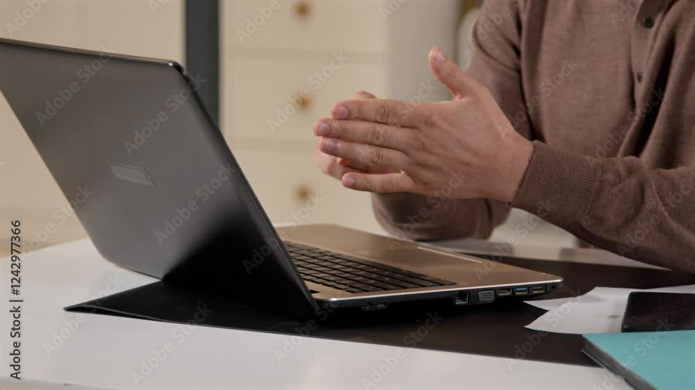 Close-up of deaf-mute mature man talking with sign language, communicating with friend online on video conference call while relaxing at home in evening. Close-up of deaf-mute mature man talking with sign language, communicating with friend online on video conference call while relaxing at home in evening.