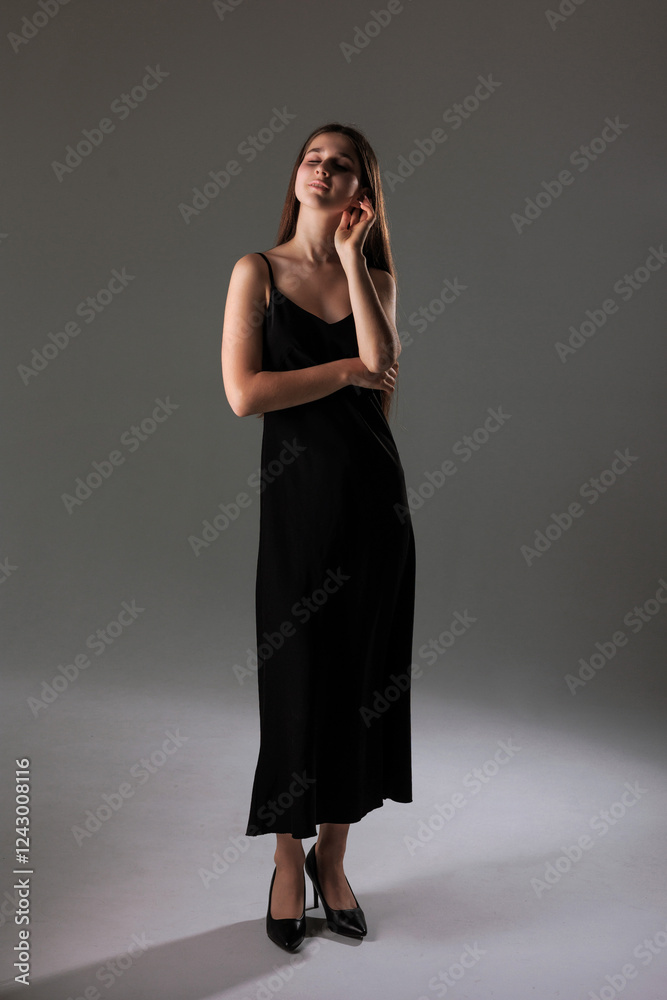 Elegant woman in a sleek black dress poses thoughtfully in a minimalist backdrop during a studio photoshoot Elegant woman in a sleek black dress poses thoughtfully in a minimalist backdrop during a studio photoshoot