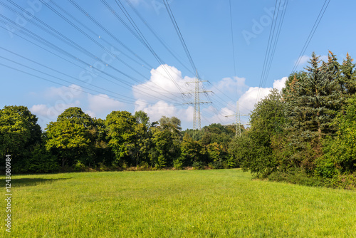 High-voltage power line over a green field in North Rhine-Westphalia, Germany in autumn