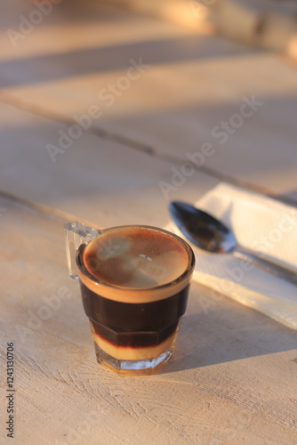 Coffee Drink Sits with Spoon on Table Gently in Warm Sunlight