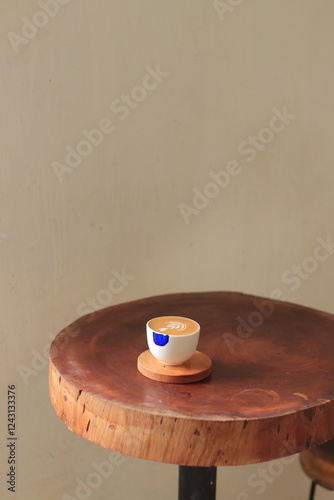 Coffee Cup Sits on Wooden Coaster with Latte Art