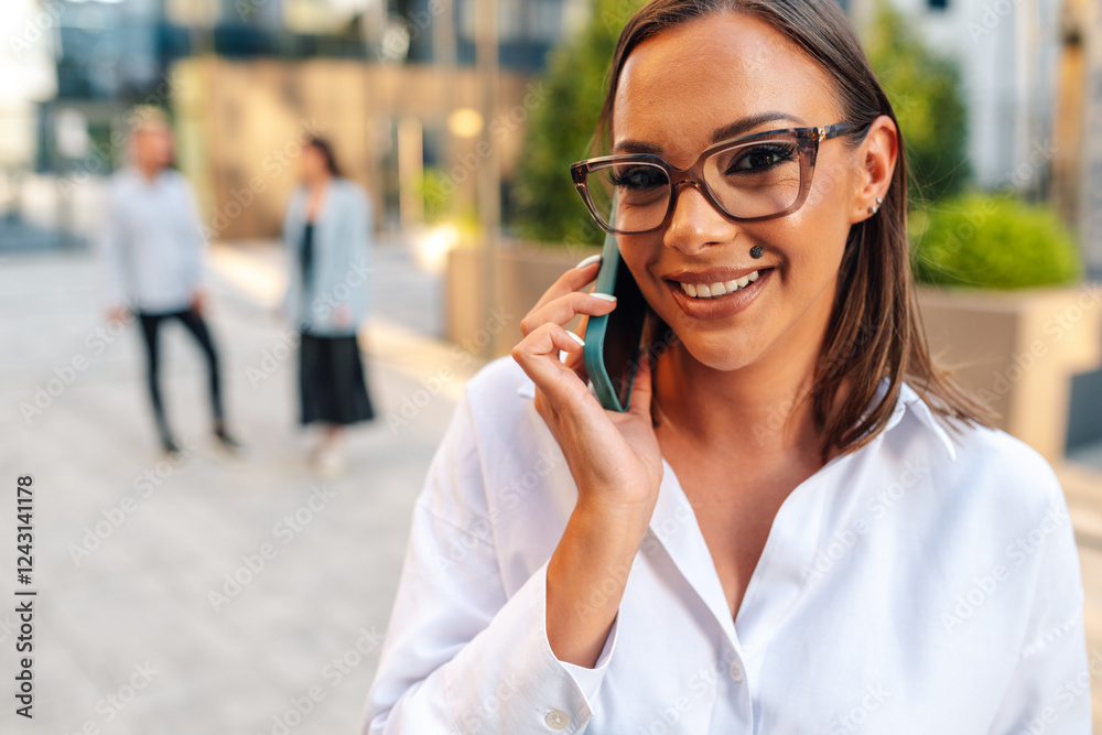 Businesswoman smiling while talking on the phone outdoors Businesswoman smiling while talking on the phone outdoors