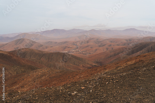 Canvas Print A barren, rocky mountain landscape in Fuerteventura under a cloudy sky