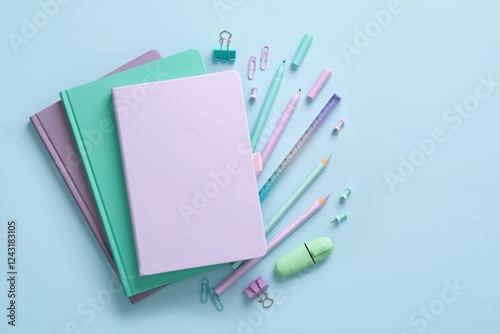 Composition of various school and office stationery in pastel mint green and purple colors on a blue background. A Place for your text.