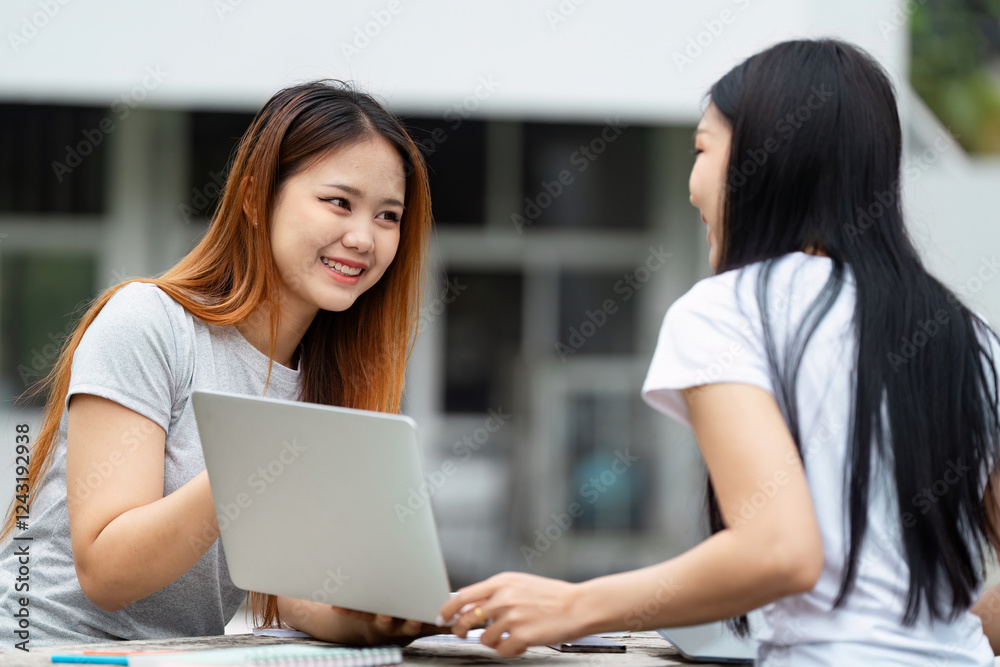 Diverse university students smiling and collaborating with a laptop. Diverse university students smiling and collaborating with a laptop.