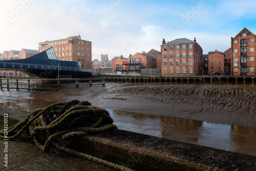 Low tide along the River Hull with bridge, flats, and church on the horizon.