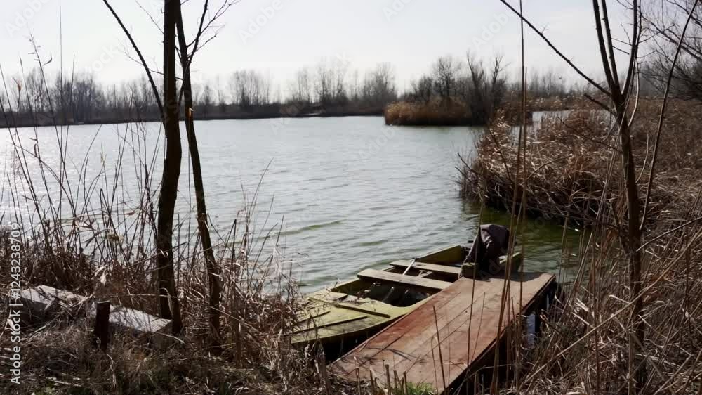 Calm retreat by the water with a rustic boat and tranquil surroundings in a natural setting Calm retreat by the water with a rustic boat and tranquil surroundings in a natural setting