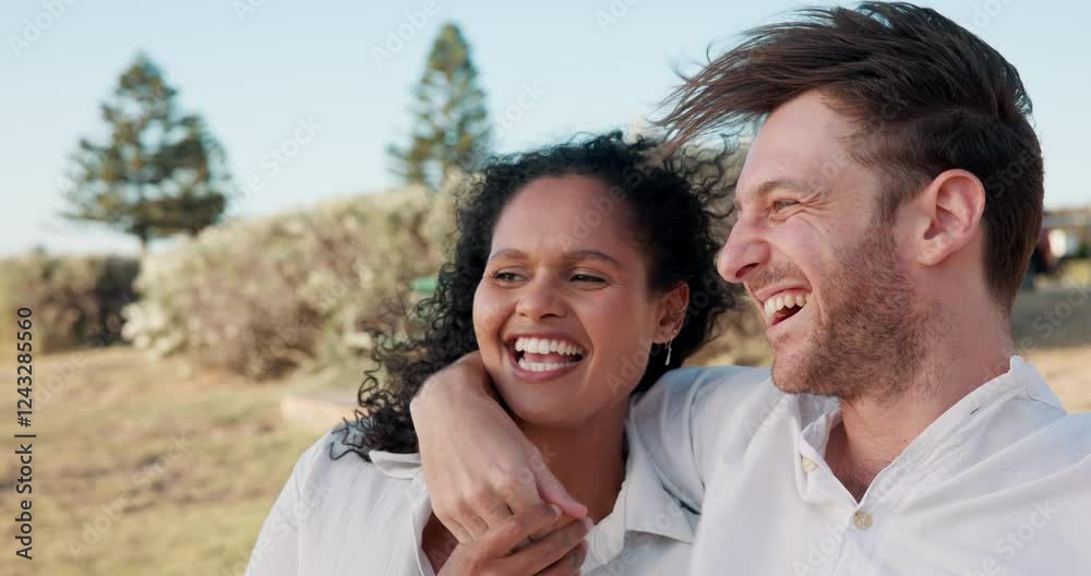 Happy couple, pointing and hug with wind in nature for date, valentines day or bonding together. Man, woman or interracial smile, embrace or love in care for anniversary, laughing or joke at park