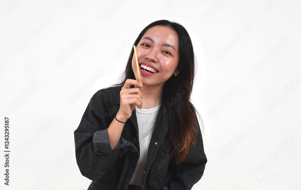 Smiling asian woman with long hair wearing denim jacket holding one piece of biscuit stick with vanilla or cheese cream dip flavor isolated on horizontal white background. Smiling asian woman with long hair wearing denim jacket holding one piece of biscuit stick with vanilla or cheese cream dip flavor isolated on horizontal white background.