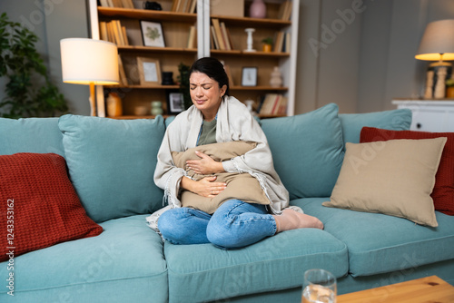 Stomach ache, cramps and hands of woman with abdomen pain due to constipation, menstruation or ibs issue. Sick, home and person suffering and holding belly in a house lounge, couch and living room