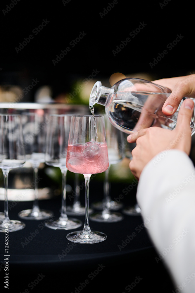 Barman pours a pink cocktail in a restaurant