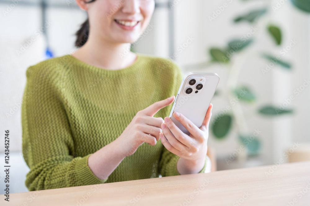 リビングでスマホを見る若い女性 リビングでスマホを見る若い女性