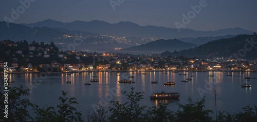 A peaceful night view of Silchar, where the Barak River mirrors the glowing city lights. The silhouette of distant hills and floating boats create a dreamy, picturesque landscape. photo