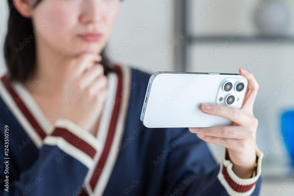 リビングでスマホを見る若い女性 リビングでスマホを見る若い女性