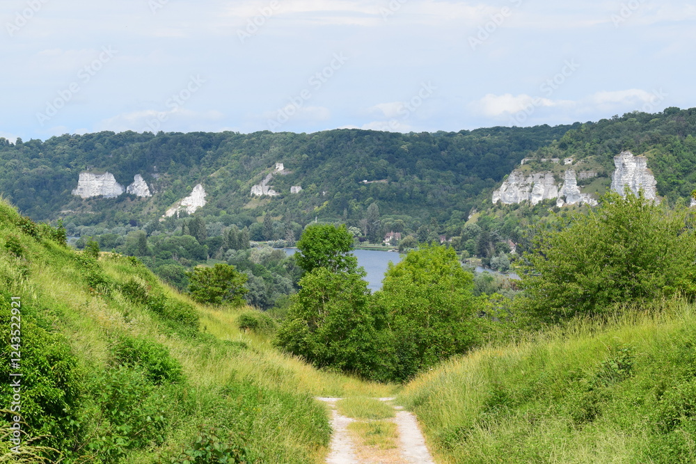 a path through a hill with views of a river, mountains and trees a path through a hill with views of a river, mountains and trees