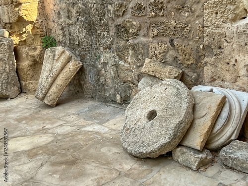 Fragments of ancient buildings located near the former St. Nichola Cathedral in Famagusta, Northern Cyprus. Among others, a millstone, e.g. from an olive oil press photo