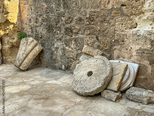 Fragments of ancient buildings located near the former St. Nichola Cathedral in Famagusta, Northern Cyprus. Among others, a millstone, e.g. from an olive oil press photo