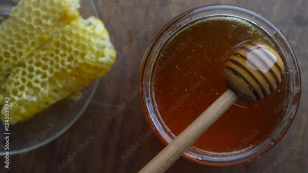 Fresh honey with wooden honey dipper, close up. Healthy eating concept. Organic floral honey in glass jar, top view Fresh honey with wooden honey dipper, close up. Healthy eating concept. Organic floral honey in glass jar, top view
