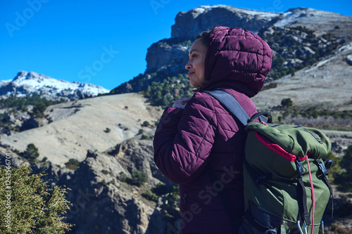 A traveler with a backpack gazes at the scenic mountain landscape photo