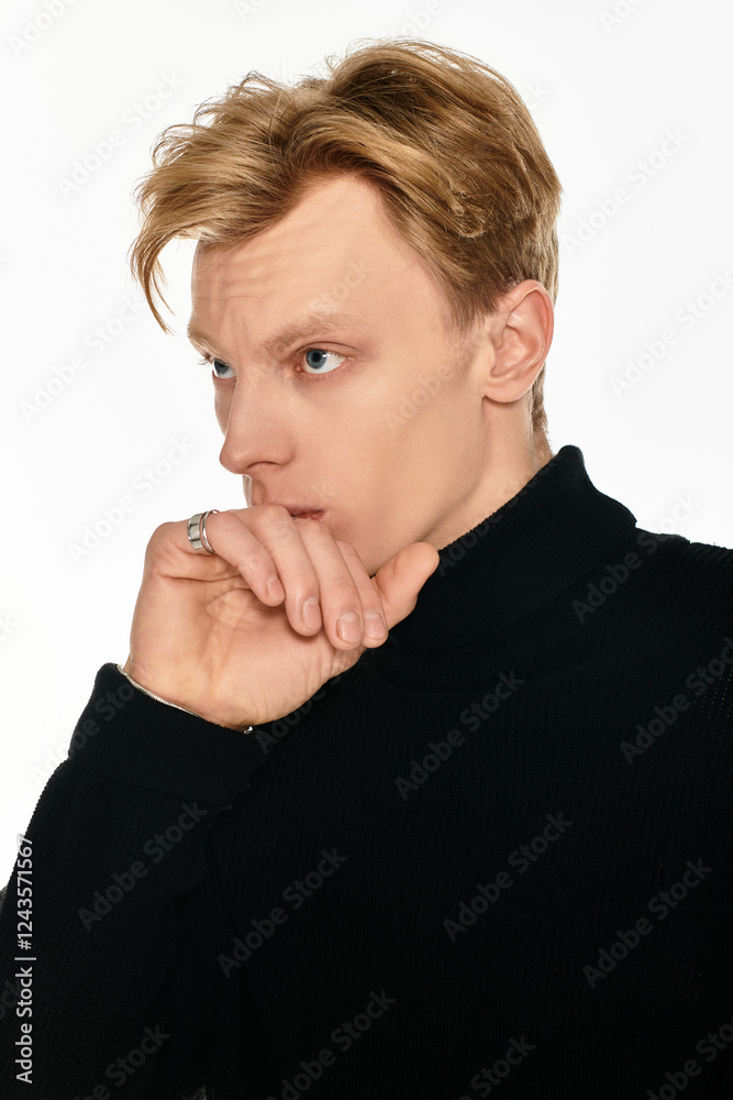Young handsome man in thoughtful pose against minimal background during indoor shoot Young handsome man in thoughtful pose against minimal background during indoor shoot