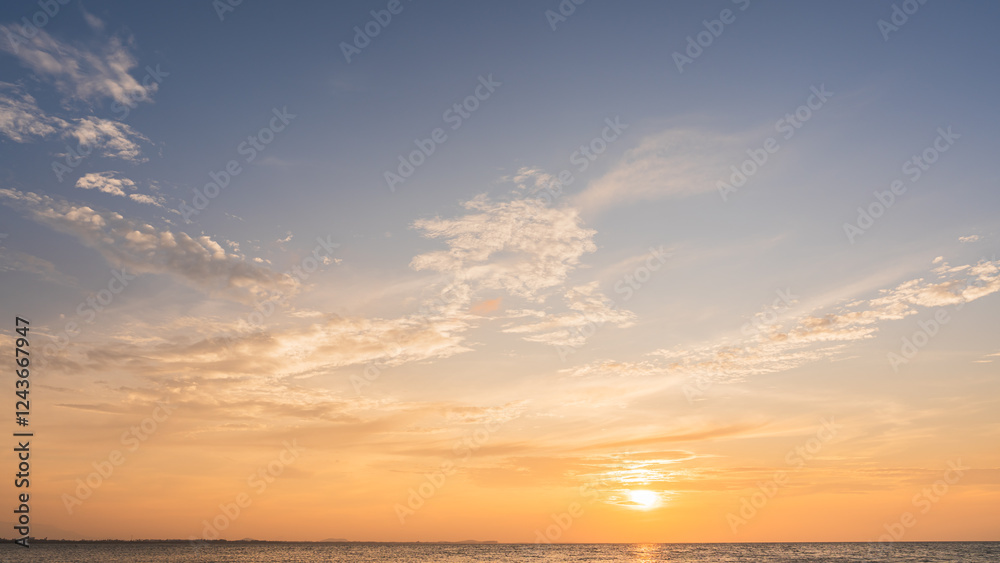 Fototapeta premium Orange sunset sky clouds over sea in the evening with yellow sunlight, Horizon sea sky landscape background and sun down in golden hour summer season, Dusk