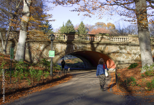 New Yorkers strolling through historic Glade Arch in Central Park on an Autumn afternoon.