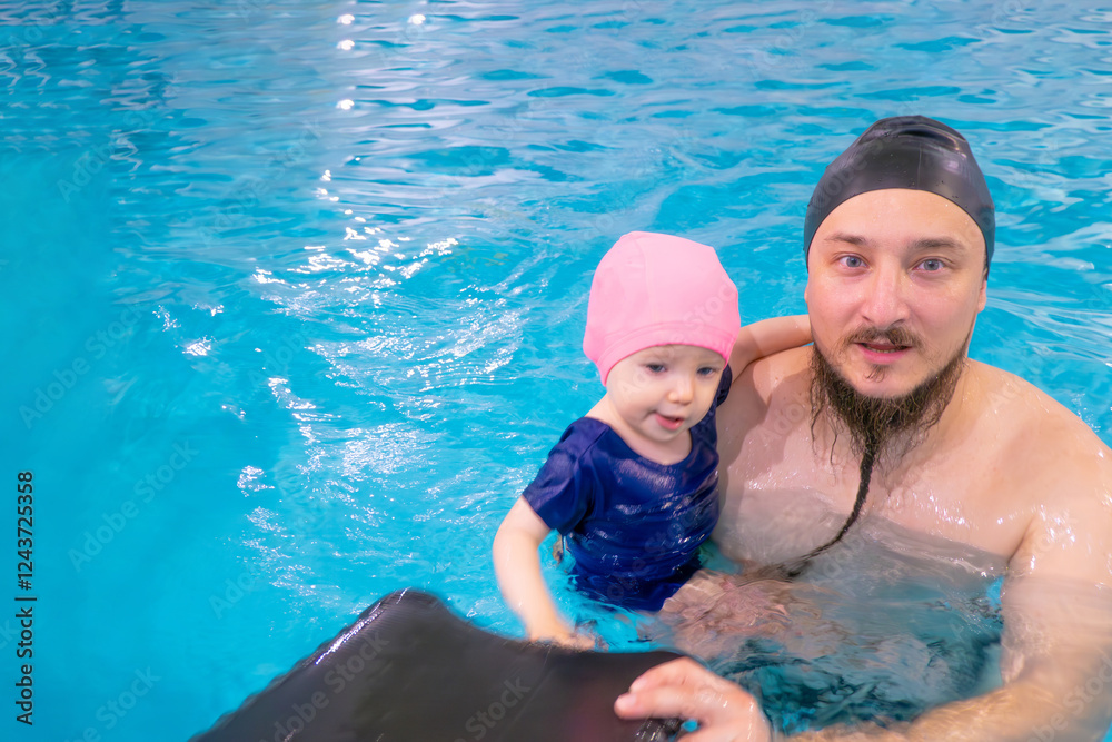 Happy middle-aged father swimming with cute adorable baby in swimming pool. Smiling dad and little child, girl having fun together. Active family spending leisure and time in spa hotel. Concept of