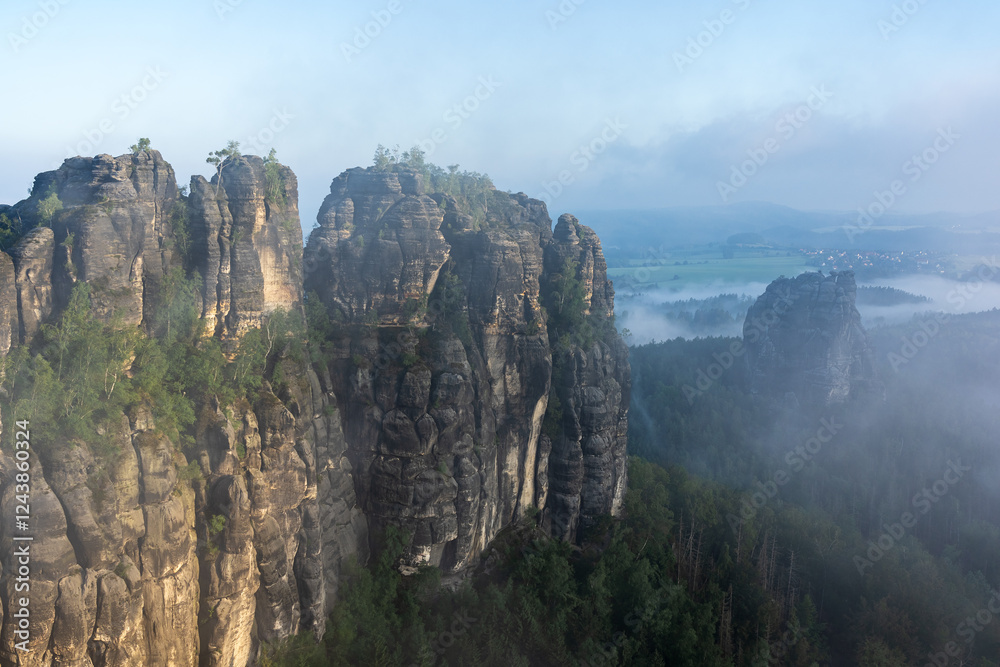 Fototapeta premium An early morning in mountain. Schrammsteine - group of rocks are a long, strung-out, very jagged in the Elbe Sandstone Mountains located in Saxon Switzerland in East Germany.