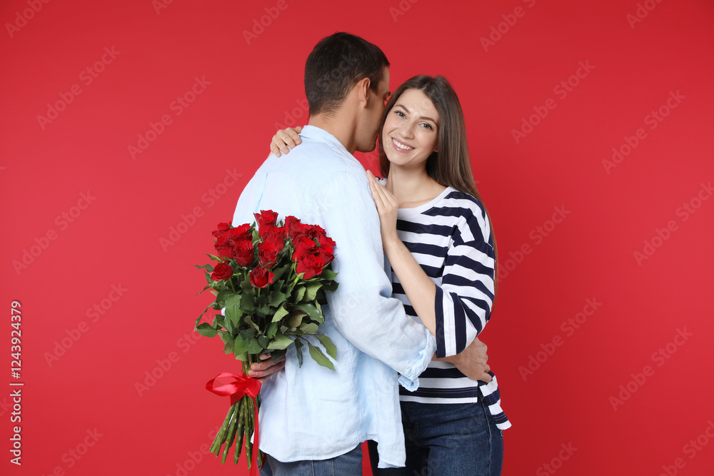 Φωτογραφία Lovely man hiding bouquet of roses for his beloved woman on red background
