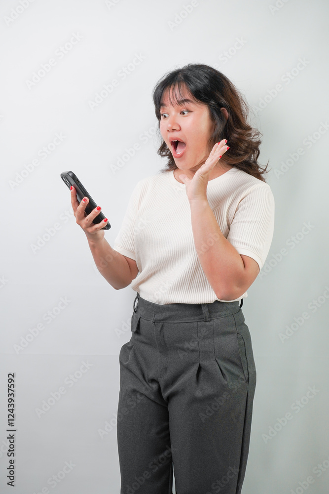 Beautiful young asian woman with wavy hair wearing white shirt is using a smartphone, isolated over white background. Beautiful young asian woman with wavy hair wearing white shirt is using a smartphone, isolated over white background.