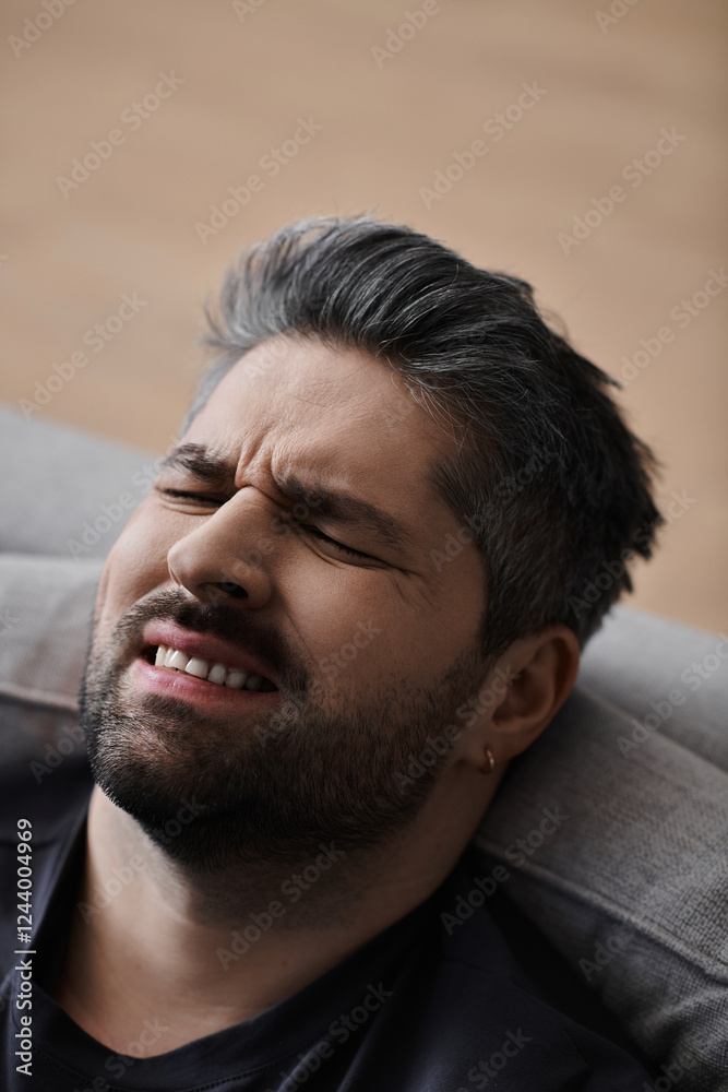 Obraz premium Handsome man enjoying a moment of contemplation in a cozy indoor setting