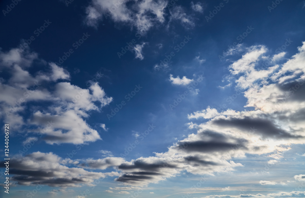 White and gray clouds in a bright blue sky, clouds signaling a weather change, blue sky with gray clouds, clusters of gray clouds in the blue sky stretching to the horizon, cloudy weather. White and gray clouds in a bright blue sky, clouds signaling a weather change, blue sky with gray clouds, clusters of gray clouds in the blue sky stretching to the horizon, cloudy weather.