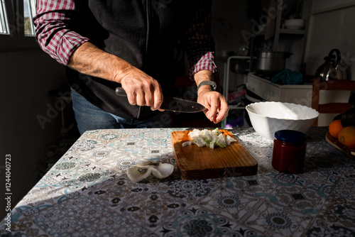 Chef cutting onion and celery on wooden board in rustic kitchen photo