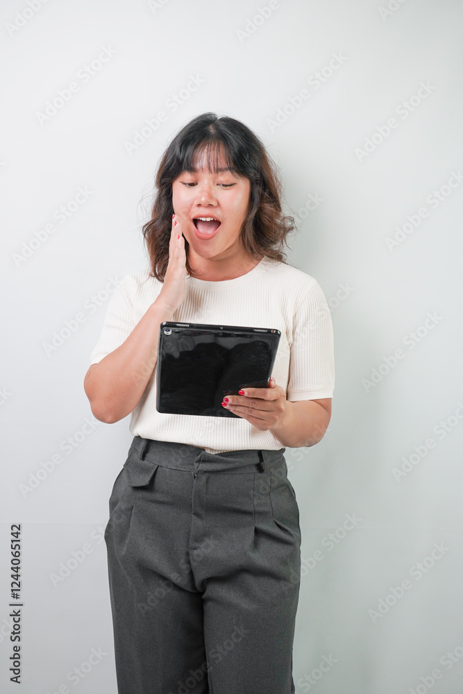 Beautiful young asian woman with wavy hair wearing white shirt holding a tablet, isolated over white background. Beautiful young asian woman with wavy hair wearing white shirt holding a tablet, isolated over white background.